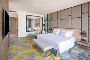 een slaapkamer met een groot wit bed en een televisie bij Melia Vinpearl Thanh Hoa in Thanh Hóa