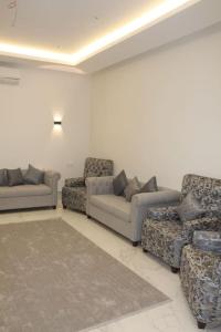 a living room with couches and chairs in a room at فيلا عصرية بمدخل خاص و مسبح in Riyadh