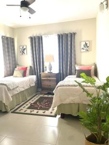 1 Schlafzimmer mit 2 Betten und einem Fenster in der Unterkunft Seashore Vacation Home, Oceanpointe, Lucea, Jamaica in Point