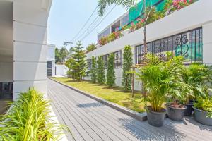 einen Korridor eines Gebäudes mit Pflanzen und Blumen in der Unterkunft GM Residence in Bangkok