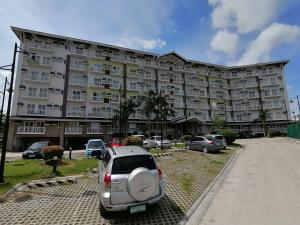a car parked in front of a large building at Condo Azur Suites A326 Amani Resorts Residences , 5 minutes Airport, Netflix, Stylish, Cozy with Luxurious Swimming Pool in Pusok