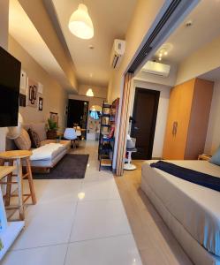 een slaapkamer met een bed en een woonkamer bij Cozy Minimalist Unit at BGC Mall Free Parking in Manilla