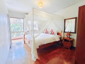 a bedroom with a bed with a canopy at Apilapa House in Chiang Mai