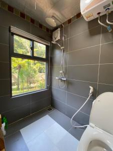 a bathroom with a toilet and a window at LEE Garden - Venuestay in Hanoi