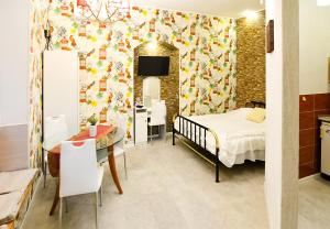 a bedroom with a bed and a table and a dining room at Apartments near Opera House in Lviv