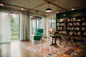 a living room with a library with chairs and a table at LEE & Sau Sau Garden - Venuestay in Hanoi
