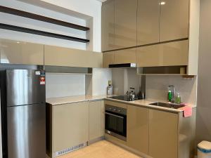 a kitchen with a stainless steel refrigerator and a sink at Lucentia Residence BBCC Lalaport at Kuala Lumpur By Luxe Home in Kuala Lumpur