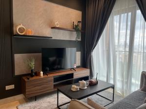 sala de estar con TV y sofá en Lucentia Residence BBCC Lalaport at Kuala Lumpur By Luxe Home, en Kuala Lumpur