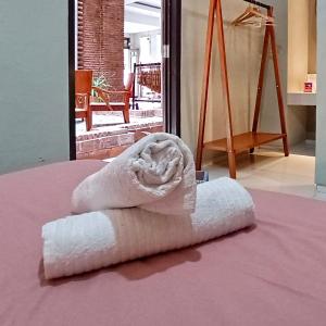 a towel sitting on top of a bed at Sabi Guest House with Strategic Hostel Styles at Prawirotaman Tourist Area by Sabi House in Yogyakarta