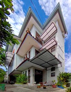 - un bâtiment avec des balcons sur le côté dans l'établissement Sabi Guest House with Strategic Hostel Styles at Prawirotaman Tourist Area by Sabi House, à Yogyakarta