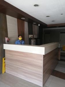 a man wearing a face mask behind a counter at Condo Azur Suites A326 Amani Resorts Residences , 5 minutes Airport, Netflix, Stylish, Cozy with Luxurious Swimming Pool in Pusok