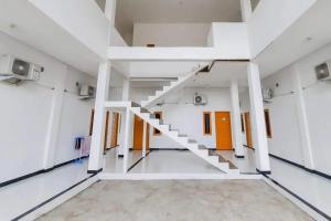 un pasillo vacío con escaleras en un edificio en RedDoorz at Permana Homestay near Supadio Airport Pontianak, en Limbung