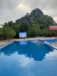 duży błękitny basen z górą w tle w obiekcie Tam Coc Sunshine Resort w mieście Ninh Binh