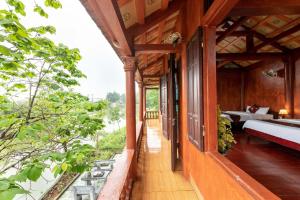 balkon domu z łóżkiem i sypialnią w obiekcie Tam Coc Sunshine Resort w mieście Ninh Binh