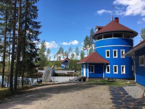 a blue lighthouse sitting next to a building at Villa Muu, LaatuLomat in Juva