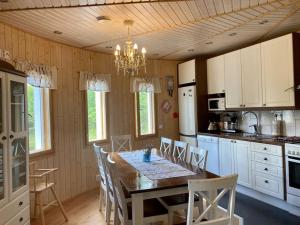 a kitchen with a table and chairs and a chandelier at Villa Muu, LaatuLomat in Juva