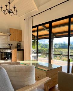 uma cozinha e sala de estar com uma mesa de vidro em Risco de Hugo em Boquete