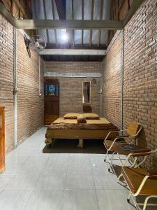 1 dormitorio con 1 cama en una pared de ladrillo en StayBareng di Kasongan en Jarakan
