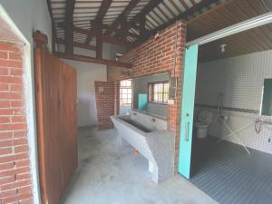 a bathroom with a sink and a brick wall at 怪獸村屋民宿 in Gukeng