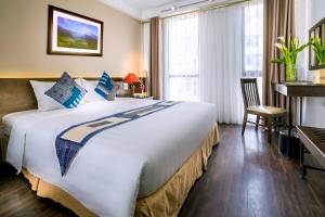 a hotel room with a large bed and a desk at Amazing Hotel Sapa in Sapa