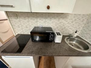 a kitchen counter with a toaster and a sink at Premium Studio Flat 04 in Central London in London