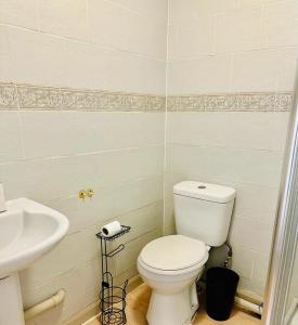 a bathroom with a white toilet and a sink at Premium Studio Flat 04 in Central London in London