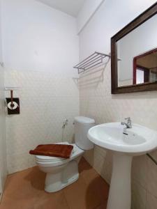 a bathroom with a sink and a toilet and a mirror at Apilapa House in Chiang Mai