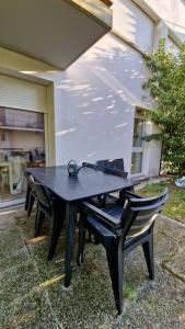 un tavolo nero e sedie di fronte a una casa di Studio jardin et terrasse a Corbeil-Essonnes