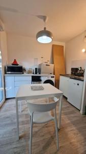 una cucina con tavolo bianco e sedia bianca di Studio jardin et terrasse a Corbeil-Essonnes