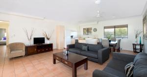 a living room with a couch and a table at Park Regis Anchorage in Townsville