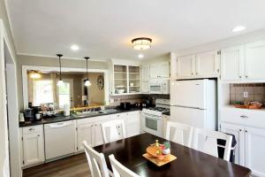 a kitchen with white cabinets and a table and chairs at Charming Mid-Century Home in Central Location in Springfield