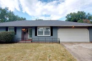 a house with a garage and a driveway at Charming Mid-Century Home in Central Location in Springfield