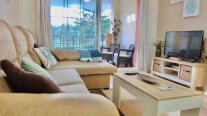 sala de estar con sofá y TV en Dream Apartment in Mijas Golf Limonar, en Mijas Costa