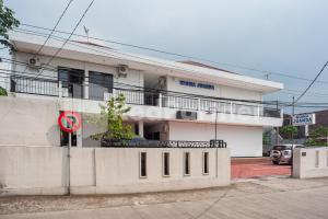 a white building with a sign in front of it at Wisma Juanda Bogor Mitra RedDoorz in Bogor