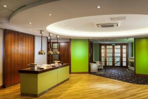 a lobby with green walls and a counter at Holiday Inn London Bloomsbury, an IHG Hotel in London