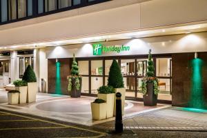 a building with potted plants in front of it at Holiday Inn London Bloomsbury, an IHG Hotel in London