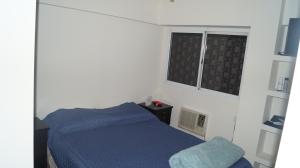 a bedroom with a blue bed and a window at Technologic Apart in San Miguel de Tucumán