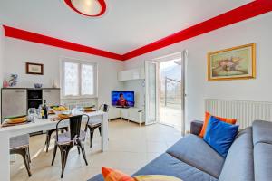 een woonkamer met een blauwe bank en een tafel met stoelen bij Il Giardino In Montagna Child Friendly - Happy Rentals in Tenno