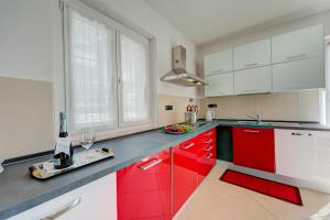 a kitchen with red and white cabinets and a bottle of wine at Il Giardino In Montagna Family Friendly- Happy Rentals in Tenno