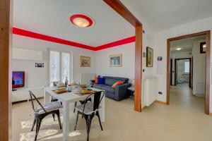 een woonkamer met een tafel en stoelen en een bank bij Il Giardino In Montagna Child Friendly - Happy Rentals in Tenno