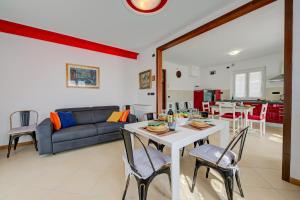 een woonkamer met een tafel en een bank bij Il Giardino In Montagna Child Friendly - Happy Rentals in Tenno