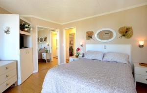 a bedroom with a white bed and a mirror at Kauhale Makai 506 in Kihei +5 photos