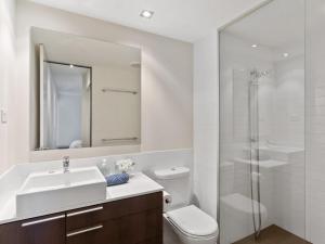 uma casa de banho com um lavatório, um WC e um chuveiro em 2bdrm Skyline Views - Prime for River, WACA, OPTUS Stadium em Perth