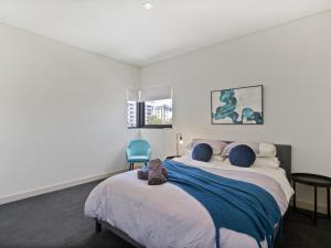 um quarto com uma cama com um gato sentado nela em 2bdrm Skyline Views - Prime for River, WACA, OPTUS Stadium em Perth