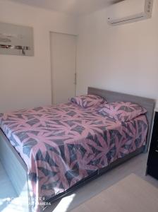 een slaapkamer met een bed met een roze en paars dekbed bij U San Francescu Maisonette Modulaire Type studio in Volpajola