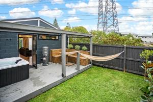 un patio trasero con una hamaca en una terraza en Studio Unit with Spa Bath en Christchurch