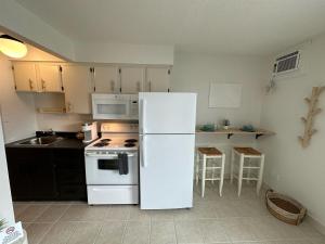 a kitchen with a white refrigerator and a stove at Lakeside Villa in Penticton