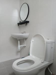 y baño con aseo, lavabo y espejo. en MY KIJANG HOMESTAY - Banglo, Alor Setar Kedah DarulAman en Alor Setar