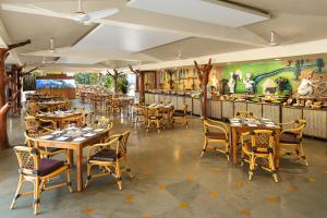 a restaurant with wooden tables and chairs and a bar at Fortune Resort Benaulim, Goa - Member ITC's Hotel Group in Benaulim