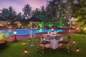 una mesa y sillas frente a una piscina en Fortune Resort Benaulim, Goa - Member ITC's Hotel Group en Benaulim